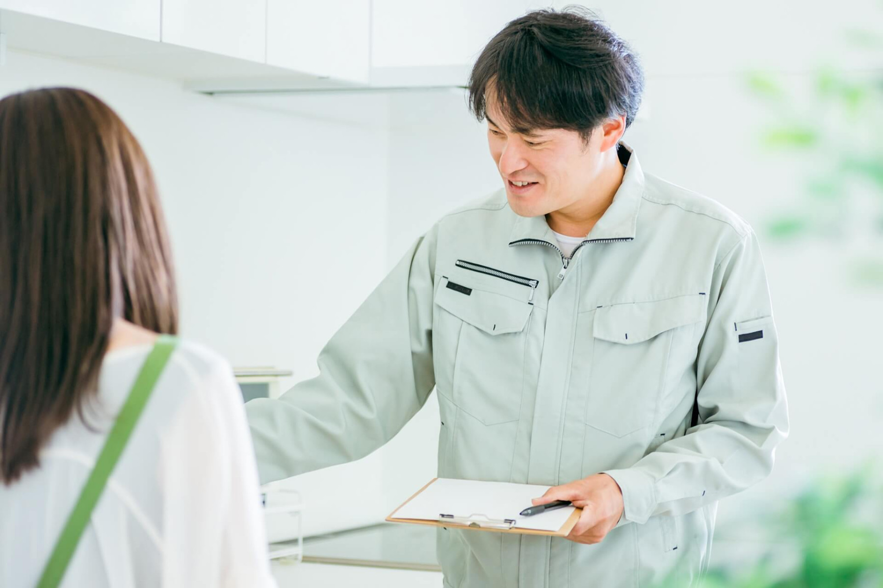 修理業者が女性に説明する場面