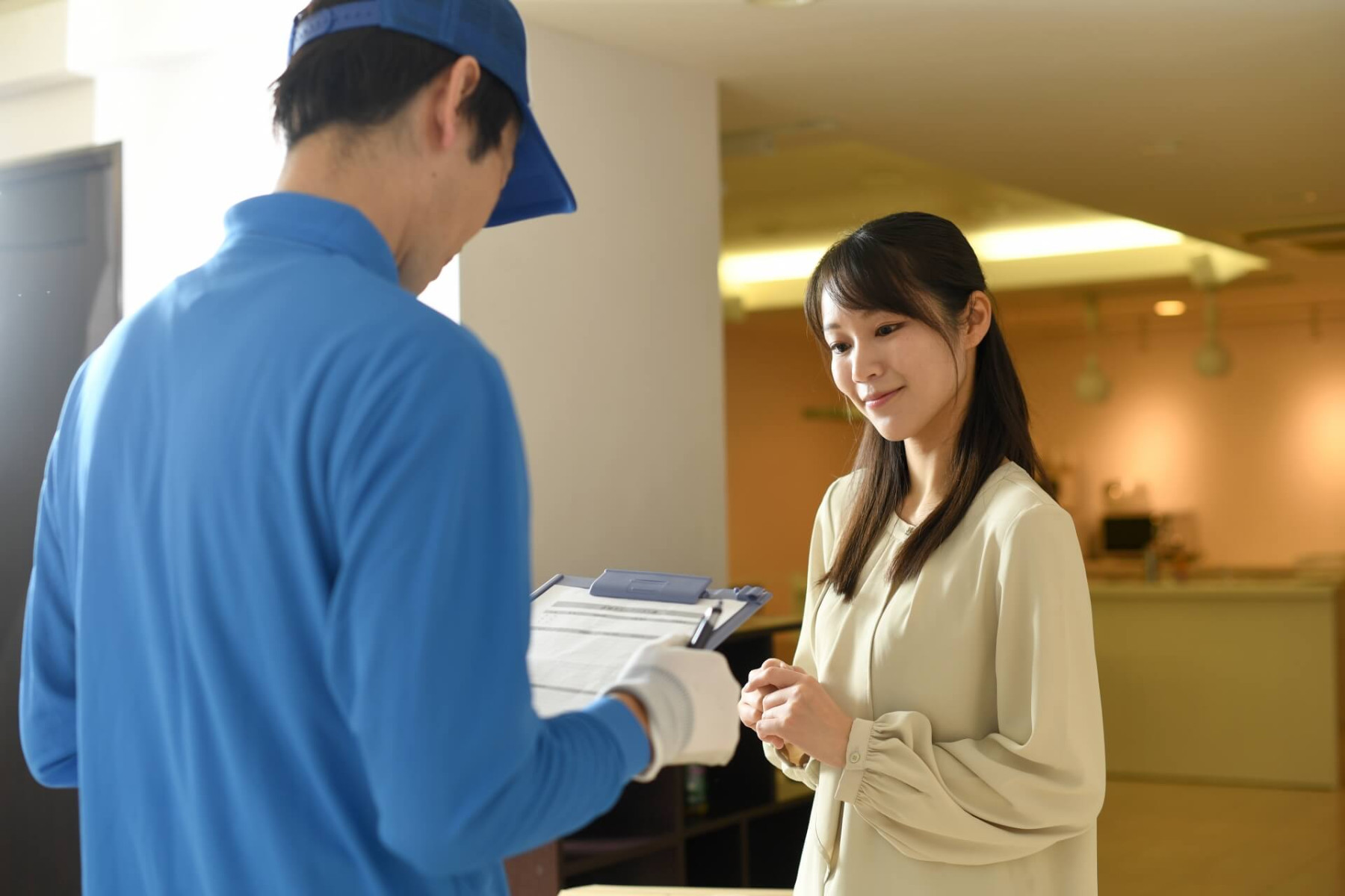 受付で配達物を受け取る女性